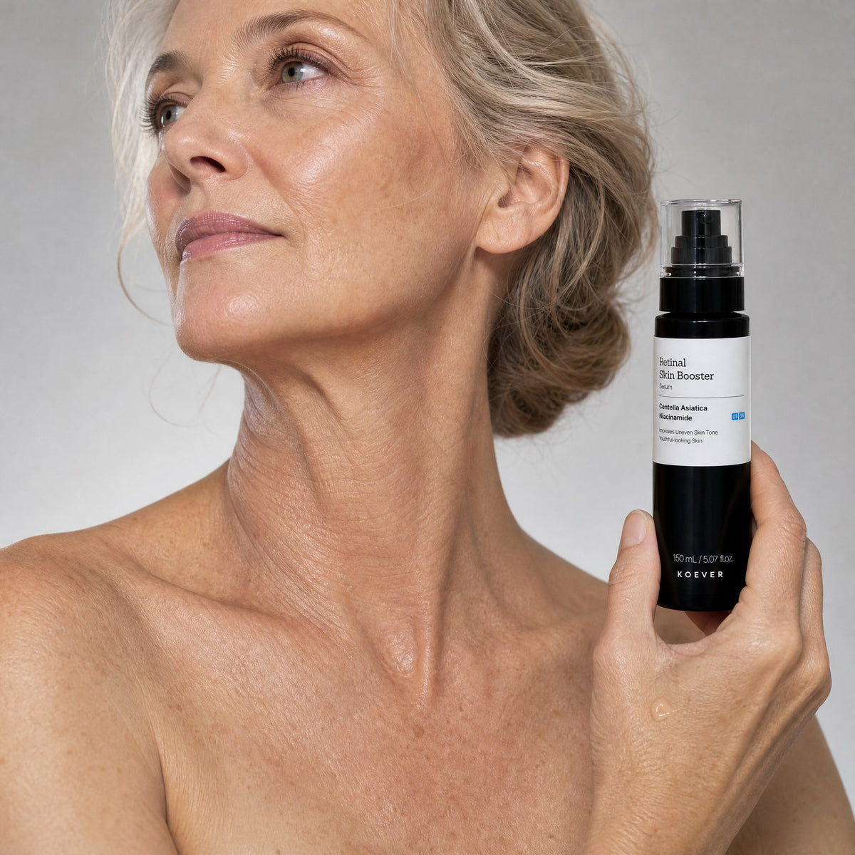 Woman holding KOEVER Retinal Neck Serum beside her neck